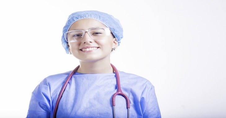 nasmejana medicinska sestra u plavoj uniformi sa providnim zaštitnim naočarama