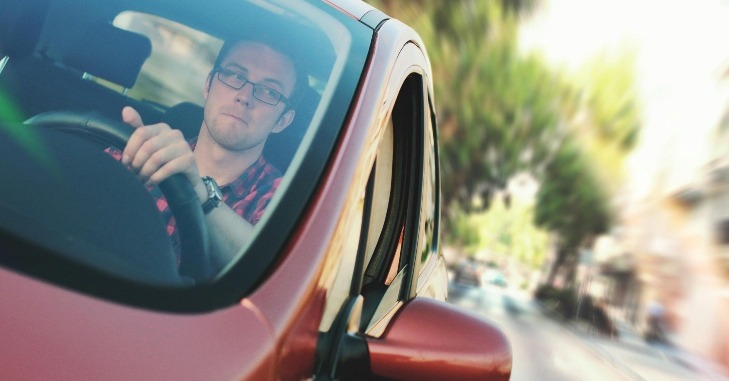 Mu&scaron;karac vozi crveni automobil