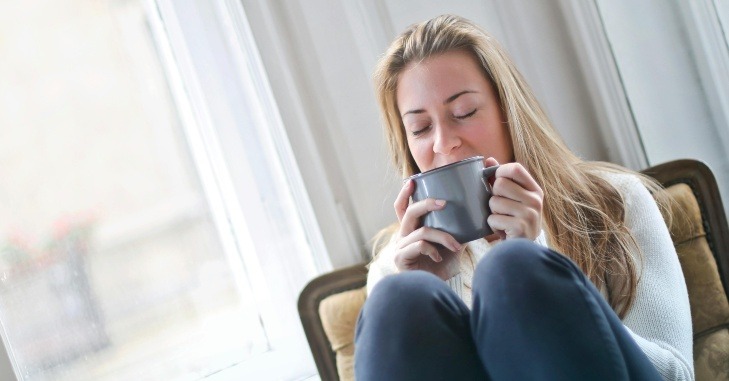 Žena pije topao napitak iz &scaron;olje