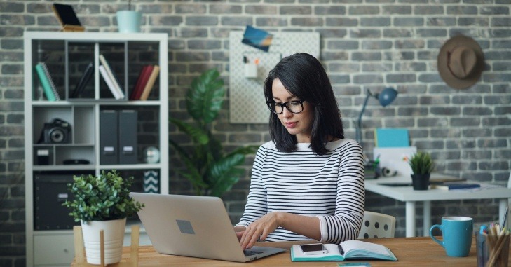 Žena kuca na laptopu.