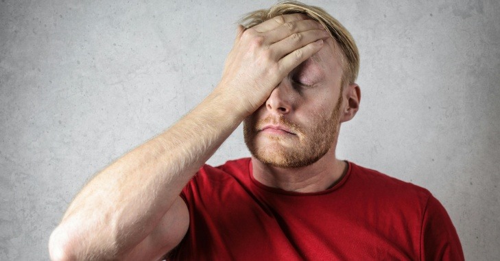 Mu&scaron;karac u crvenoj majici se drži za glavu zbog stresa