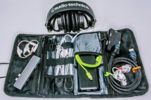 Torbica sa uredno složenim kablovima, spoljnom baterijom i slu&scaron;alicama.